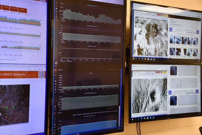 A series of monitors displaying real-time data measuring earth movement.