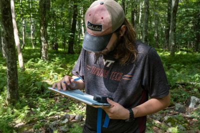 Virginia Tech researcher using camera traps in the woods